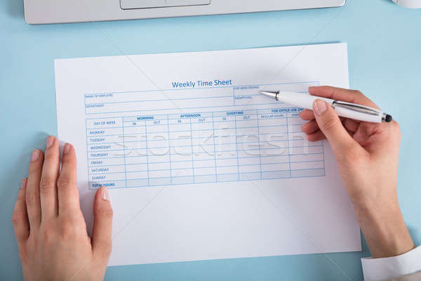 Businesswoman Filling The Weekly Time Sheet Stock photo © AndreyPopov