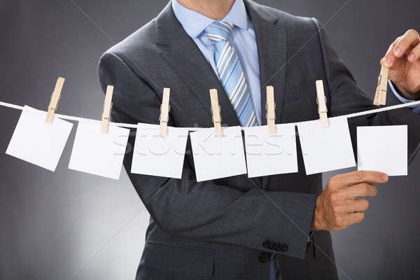 Businessman Pinning Blank Paper On Clothesline Stock photo © AndreyPopov