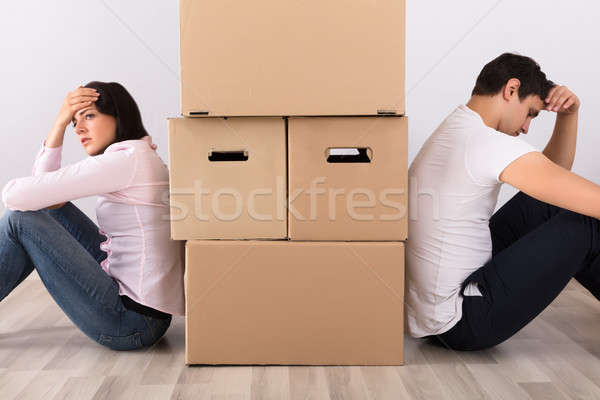 Upset Couple Sitting Back To Back Behind The Boxes Stock photo © AndreyPopov