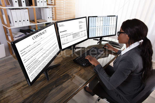 Businesswoman Checking Invoice On Computer Stock photo © AndreyPopov