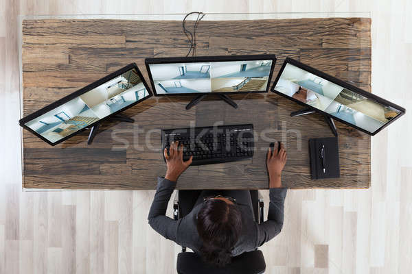 Businesswoman Looking At Multiple Camera Footage In Office Stock photo © AndreyPopov