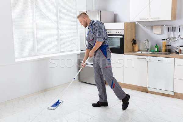 Young Male Worker Mopping Floor Stock photo © AndreyPopov
