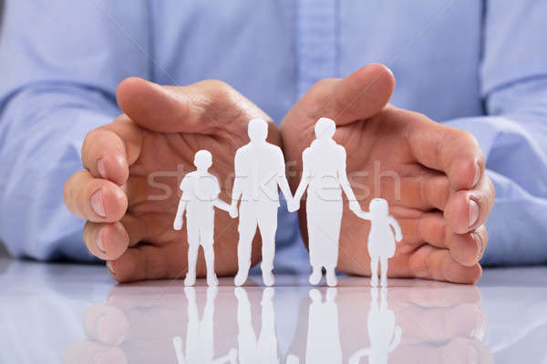 Stock photo: Businessperson Protecting Family Paper Cut Out