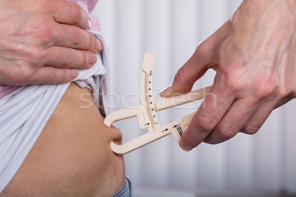 Woman Measuring Fats With Caliper Stock photo © AndreyPopov