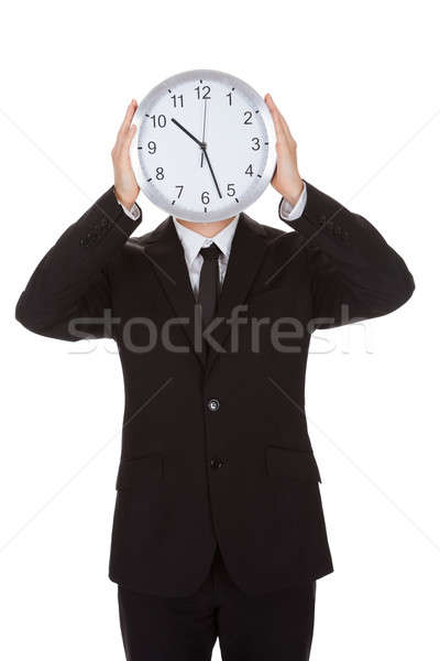 Businessman holding clock over the face Stock photo © AndreyPopov