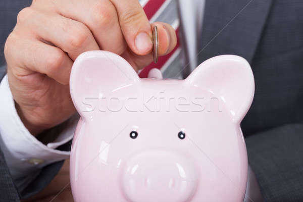 Businessman Inserting Coin In Piggybank Stock photo © AndreyPopov