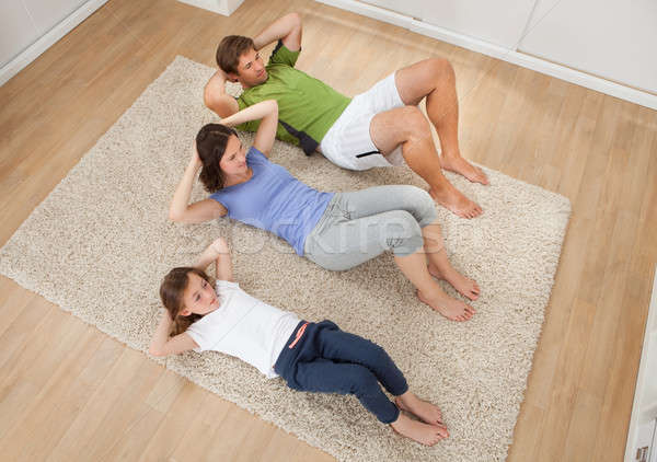 Family Doing Situps On Rug At Home Stock photo © AndreyPopov