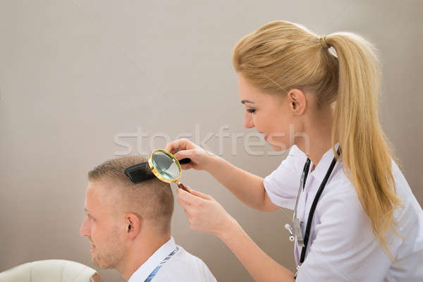 Female Dermatologist Looking Hair Through Magnifying Glass Stock photo © AndreyPopov
