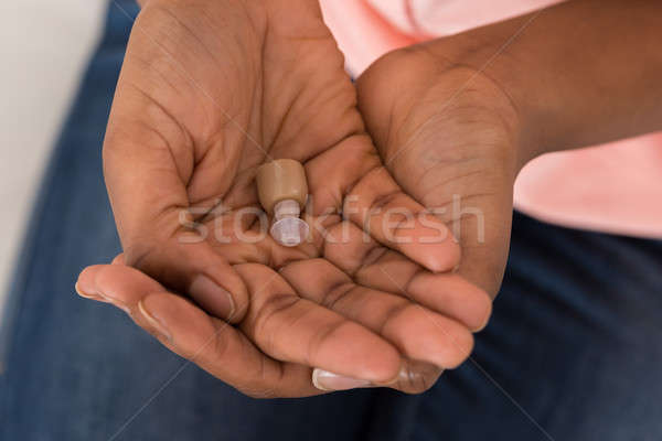 Person's Hand With Hearing Aid Stock photo © AndreyPopov