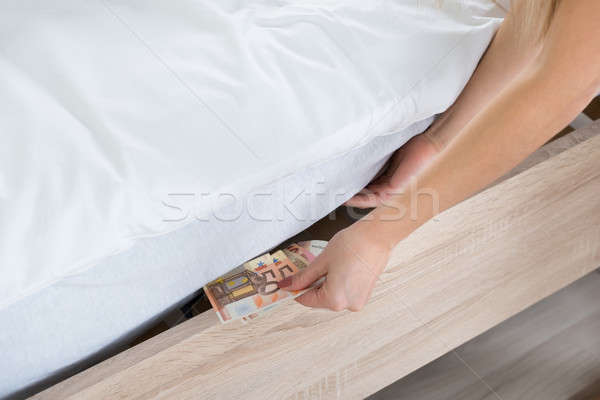 Női kéz rejtőzködik bankjegyek közelkép ágy Stock fotó © AndreyPopov