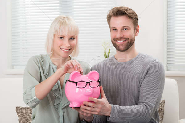 Couple Inserting Coin At Piggybank Stock photo © AndreyPopov