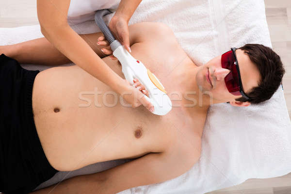 Therapist Giving Laser Epilation Treatment On Young Man's Chest Stock photo © AndreyPopov