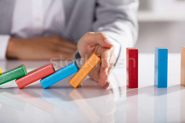 Businessperson Hand Stopping Colorful Blocks From Falling Stock photo © AndreyPopov