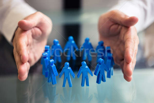 Businessperson Protecting Blue Human Figures Forming Circle Stock photo © AndreyPopov