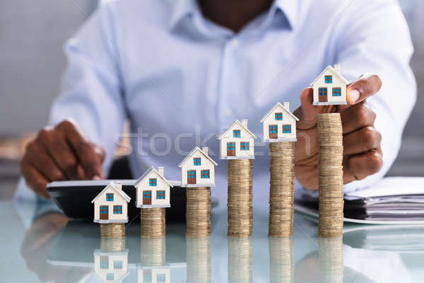 Businessperson Placing House Model On Coin Stacked Stock photo © AndreyPopov