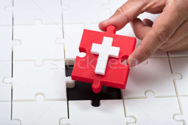 Person placing holy cross symbol piece into jigsaw puzzle Stock photo © AndreyPopov