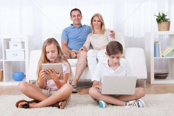 [[stock_photo]]: Enfants · tapis · comprimé · portable · parents · derrière