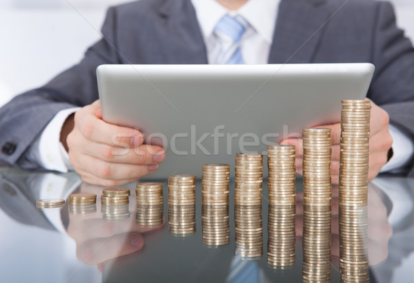 Businessman With Digital Tablet And Coin Stack Stock photo © AndreyPopov