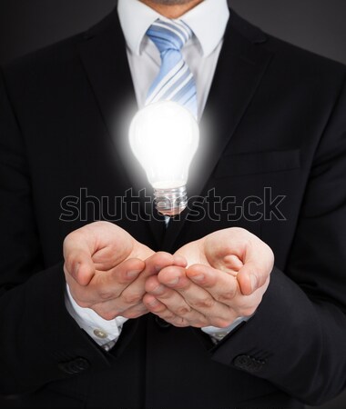 Businessman With Glowing Bulb Representing Ideas Stock photo © AndreyPopov