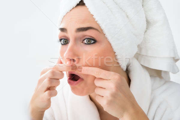 Stock photo: Shocked Woman Looking At Pimple On Face