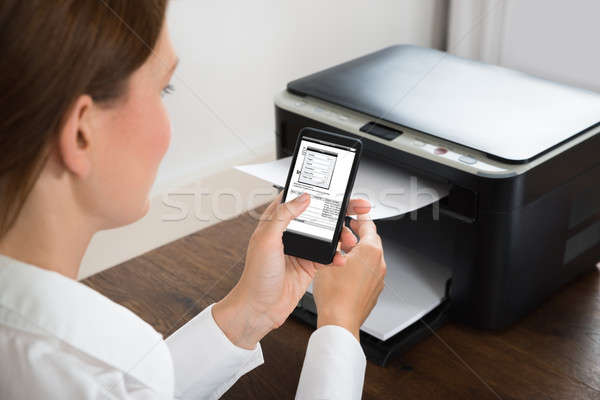 Businesswoman With Mobile Phone Connected To Printer Stock photo © AndreyPopov