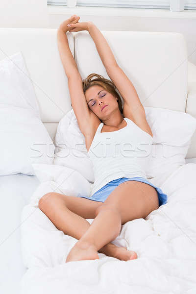 Woman Stretching Arms In Bed Stock photo © AndreyPopov