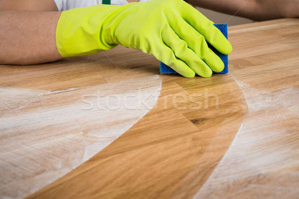 Uomo pulizia polvere tavolo in legno immagine home Foto d'archivio © AndreyPopov