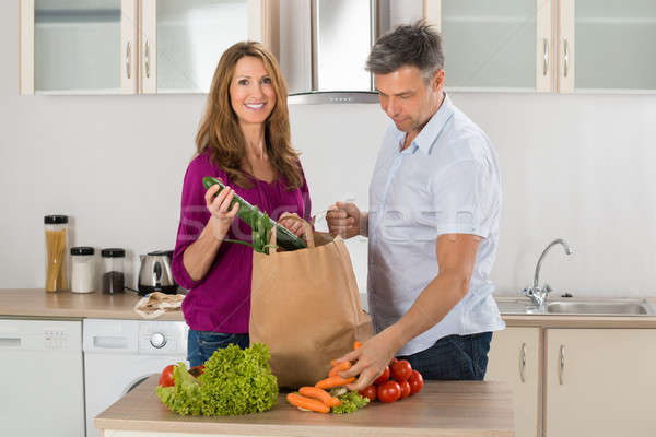 Couple Removing Vegetables From Grocery Bag Stock photo © AndreyPopov