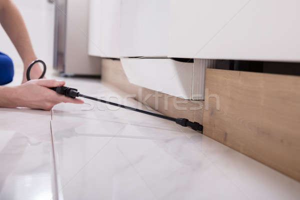 Pest Control Worker Spraying Pesticide On Wooden Cabinet Stock photo © AndreyPopov