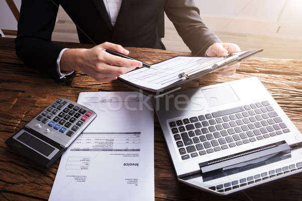 Businessperson Analyzing Document On Clipboard Stock photo © AndreyPopov