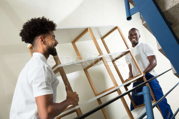 Two Male Movers Carrying The Empty Shelf At Home Stock photo © AndreyPopov