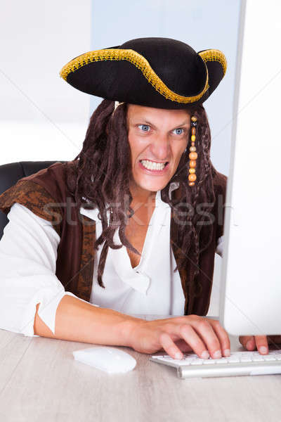 Angry Pirate Using Computer Stock photo © AndreyPopov