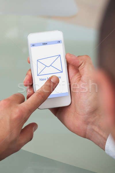 Cropped image of businessman opening message on smart phone Stock photo © AndreyPopov
