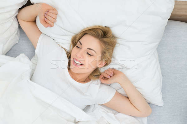 Woman Stretching Arms In Bed Stock photo © AndreyPopov