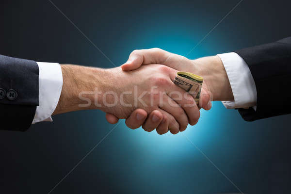 Businessman Shaking Hands While Giving Bribe To Partner Stock photo © AndreyPopov