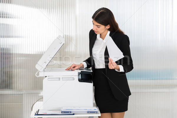 Businesswoman Using Photocopy Machine In Office Stock photo © AndreyPopov