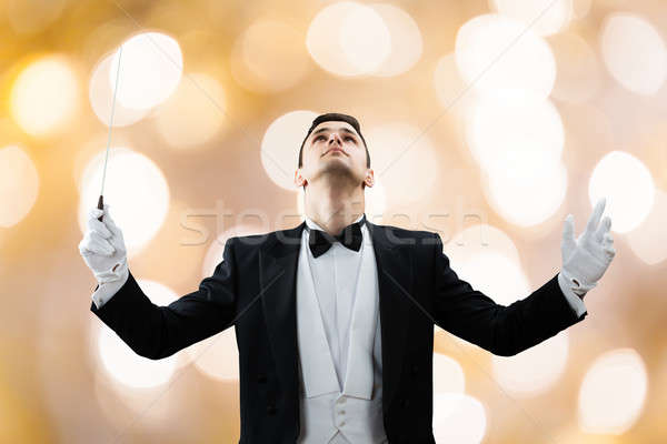 Music Conductor Looking Up While Holding Baton Stock photo © AndreyPopov