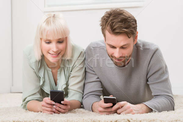Happy Couple Holding Cellphones Stock photo © AndreyPopov