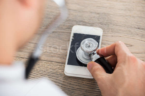 Doctor Holding Stethoscope On Broken Screen Smart Phone Stock photo © AndreyPopov