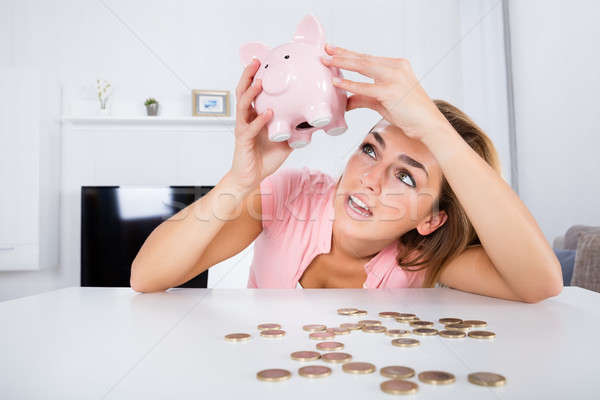 Happy Woman Emptying Her Piggybank Savings Stock photo © AndreyPopov