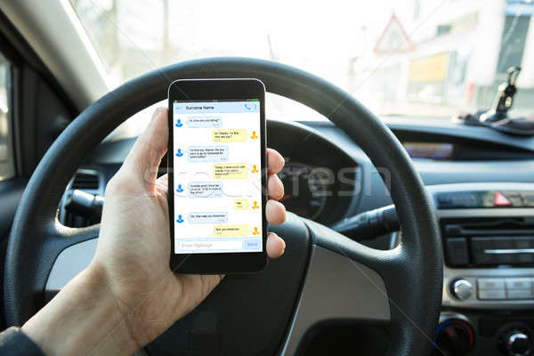 Személy küldés szöveges üzenet autó vezetés kéz Stock fotó © AndreyPopov