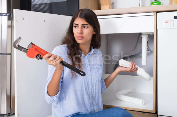 Woman Holding Sink Pipe And Monkey Wrench Stock photo © AndreyPopov