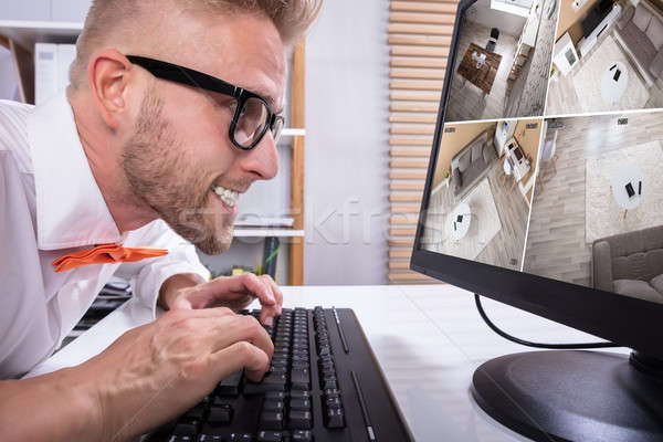 Businessman Looking CCTV Footage In Office Stock photo © AndreyPopov