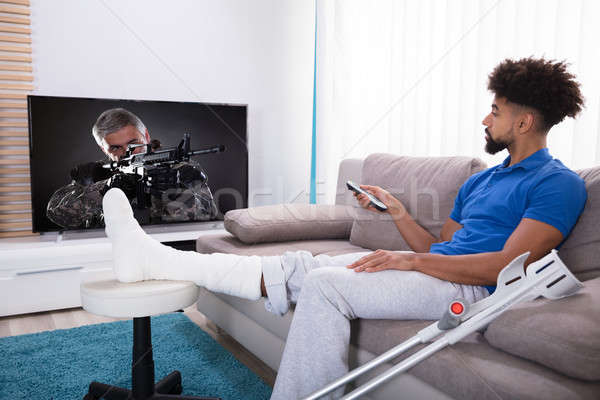 男子 斷腿 看電視 年輕人 坐在 沙發 商業照片 © AndreyPopov
