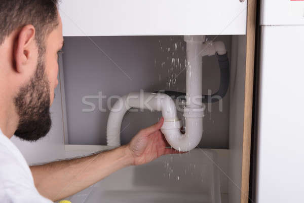 Man Looking At Sink Pipe Leakage Stock photo © AndreyPopov