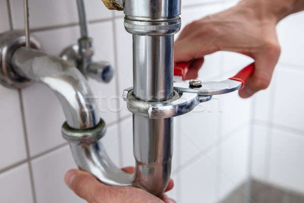 Plumber Repairing Sink With Adjustable Wrench Stock photo © AndreyPopov