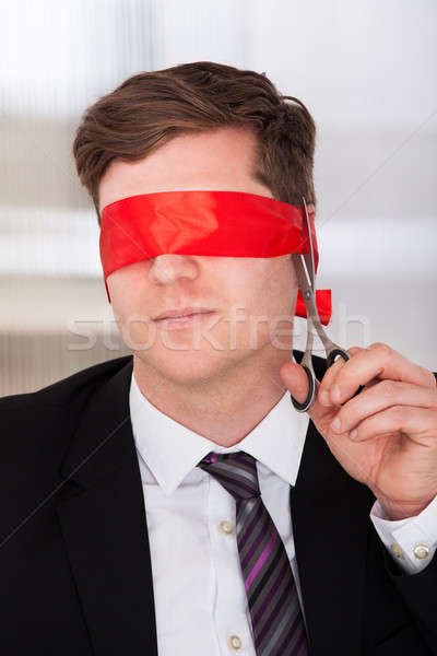 Businessman cutting his blindfold Stock photo © AndreyPopov