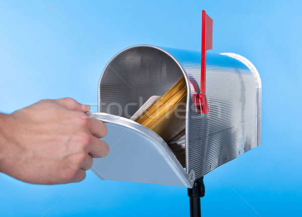 Stock photo: Man opening his mailbox to remove mail