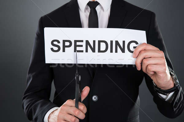 Businessman Cutting The Word Spending On Paper With Scissors Stock photo © AndreyPopov