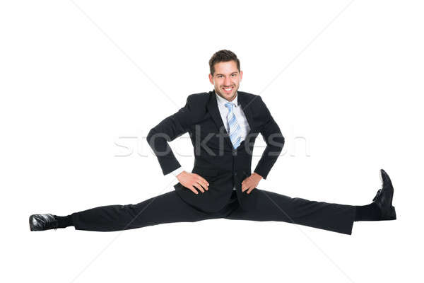 Businessman Doing Splits Over White Background Stock photo © AndreyPopov